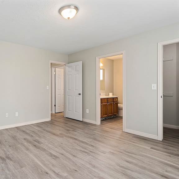 an empty living room with white walls and wood flooring