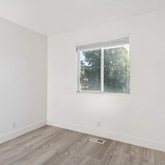 an empty room with white walls and a window