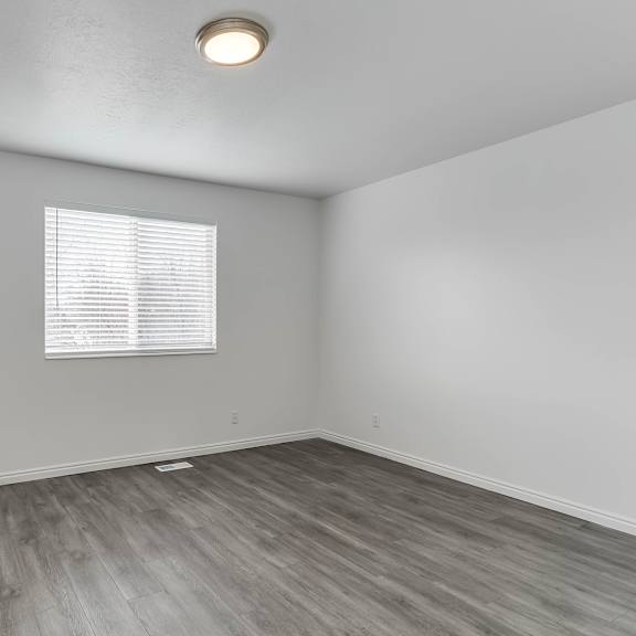 a room with a window and wooden flooring.