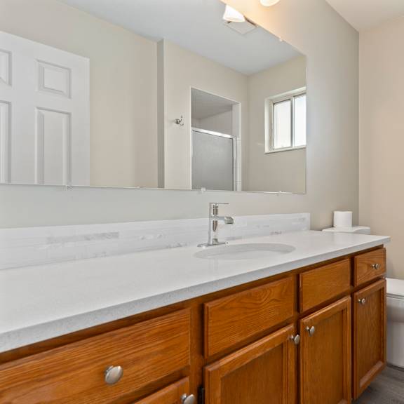 a bathroom with a large mirror and a sink and a toilet