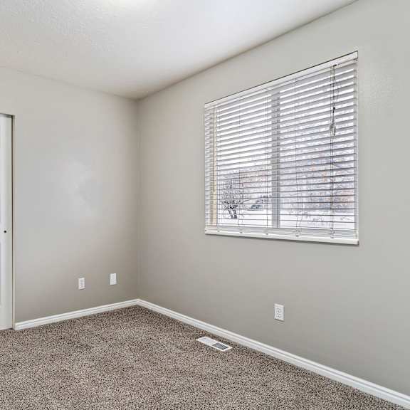 a room with a white door and a window with blinds.