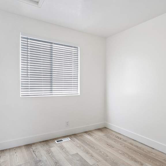 an empty room with white walls and a window