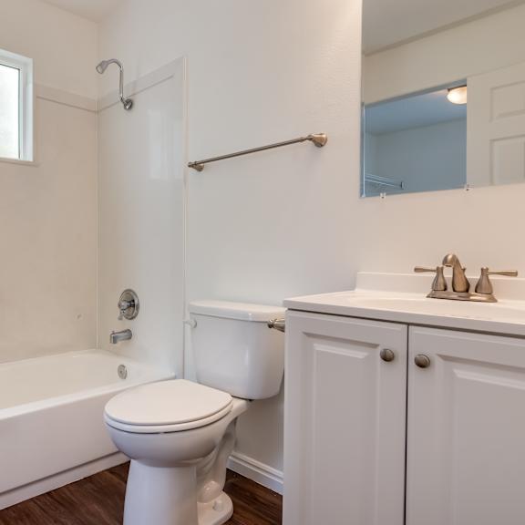 a bathroom with toilet shower and vanity