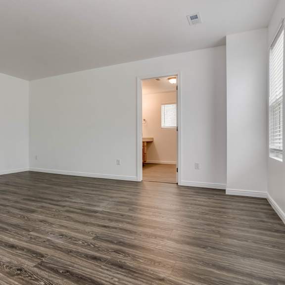 a room with wooden flooring and white walls.