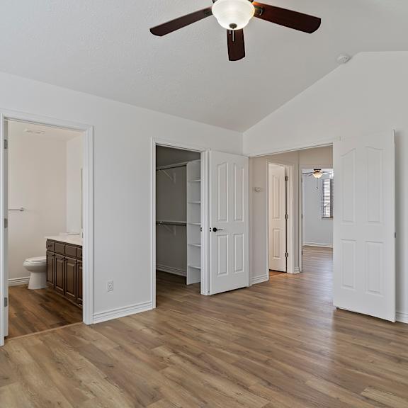 a room with a ceiling fan and wooden floors.
