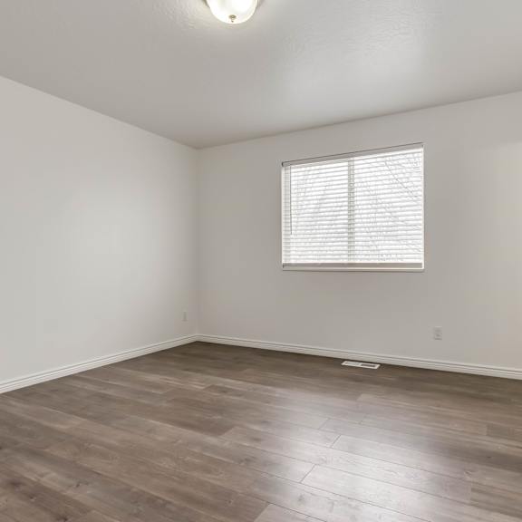 a room with a window and wooden flooring.