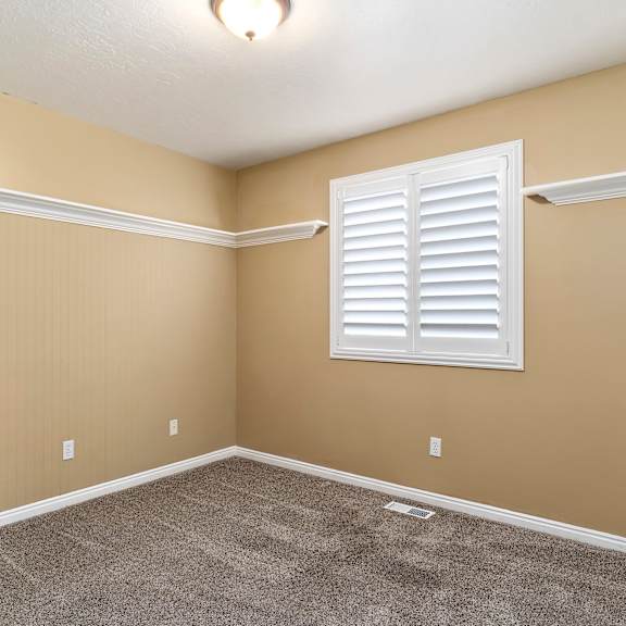 a room with a window and a carpeted floor.