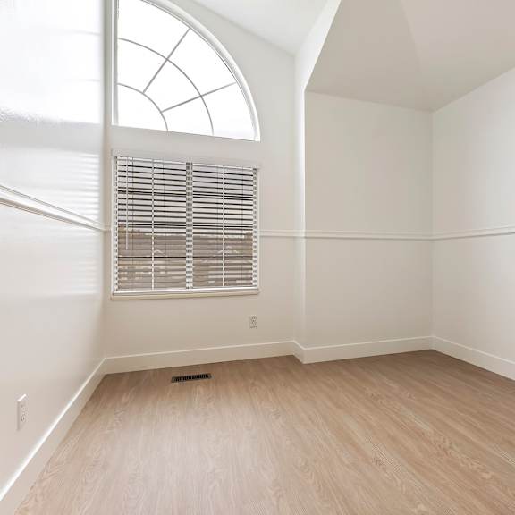 a room with a window and wooden flooring.