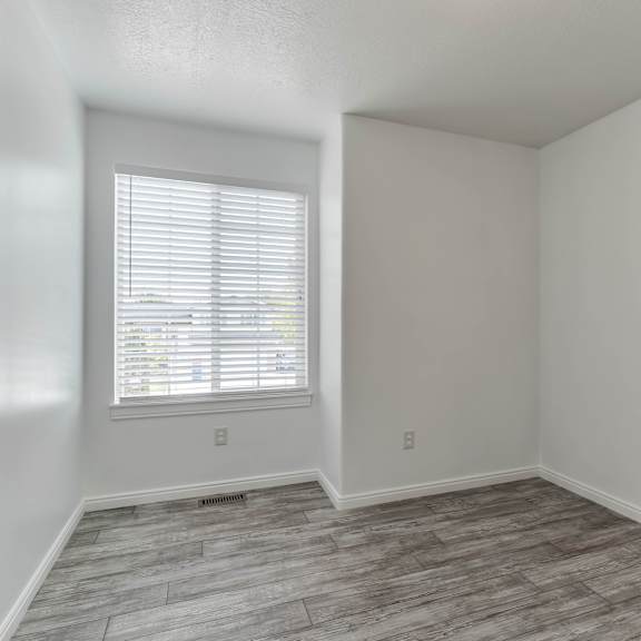 a room with a window and wooden flooring.