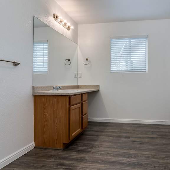 a bathroom with a wooden vanity and a bathtub.