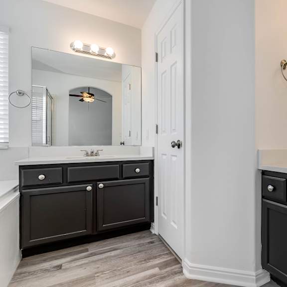 a white and black bathroom with two sinks and a mirror