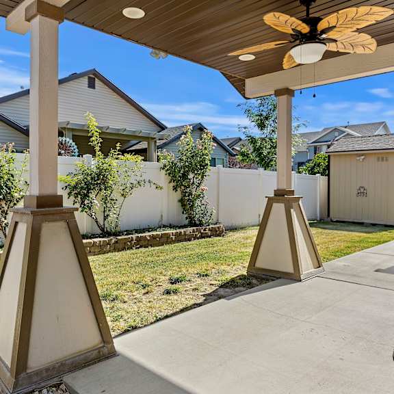 a patio with a ceiling fan and a concrete floor.