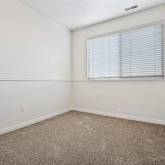 an empty room with carpet and a window