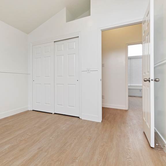 a white door is in a room with wood flooring.