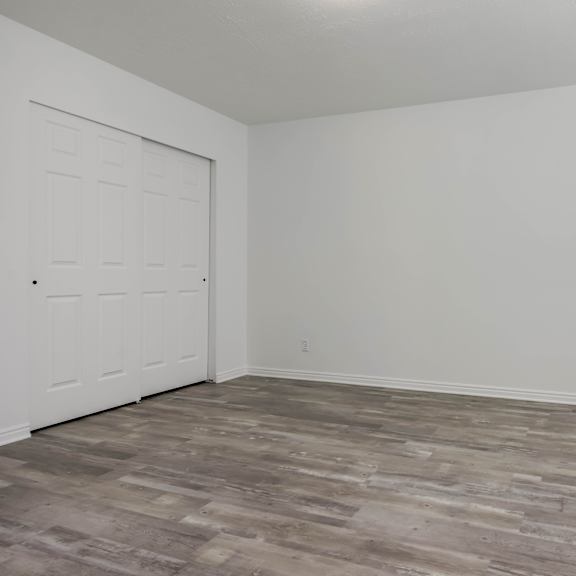 a room with a wooden floor and a white door.