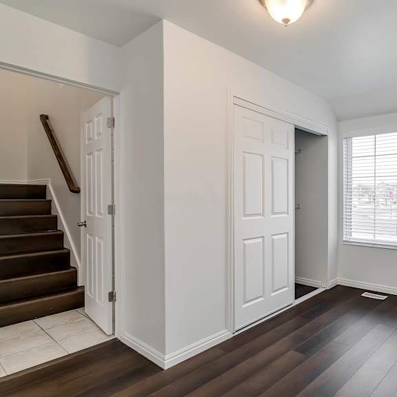 a room with a staircase and a window with blinds.