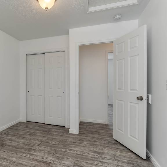 a room with a white door and a brown floor.