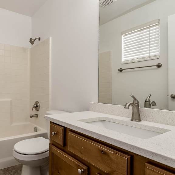 a white bathroom with a toilet, sink, and bathtub.