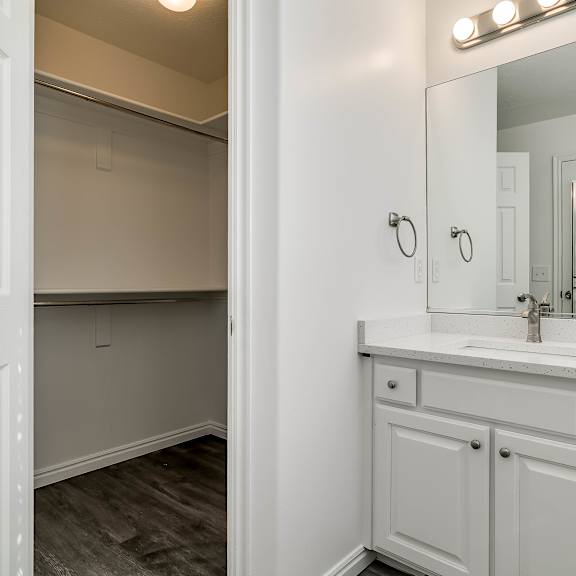 a white bathroom with a sink and mirror.