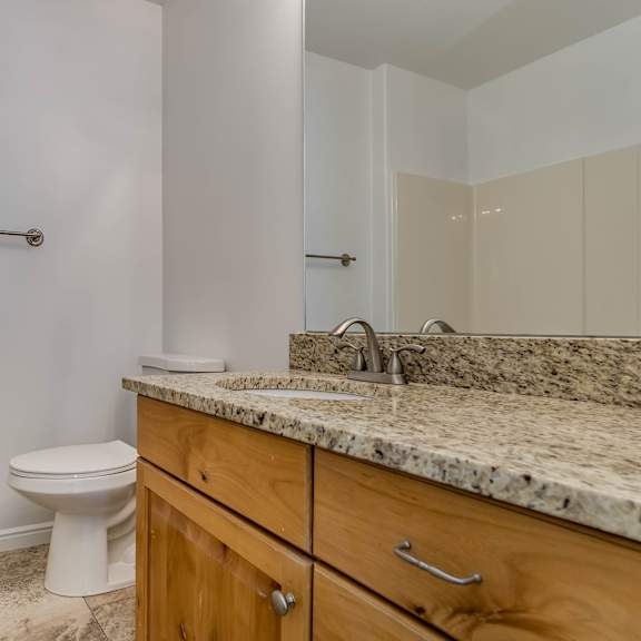 a bathroom with a toilet, sink, and a towel bar.