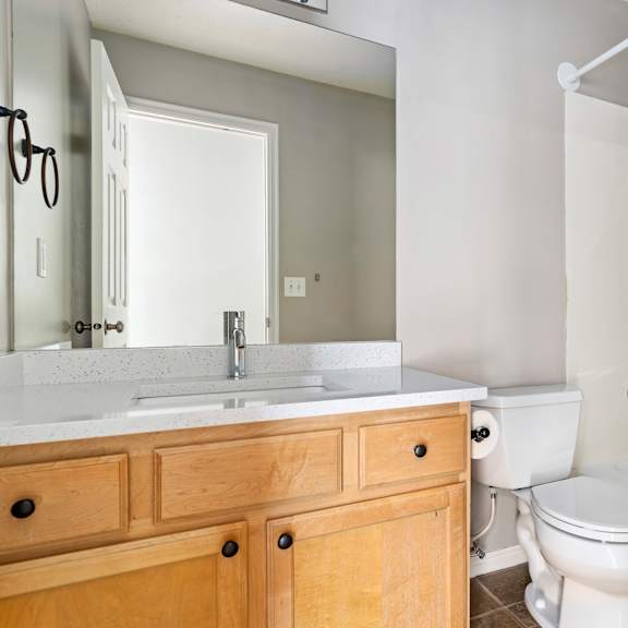 a white toilet sits next to a white sink in a bathroom.