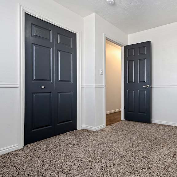 an empty room with black doors and white walls
