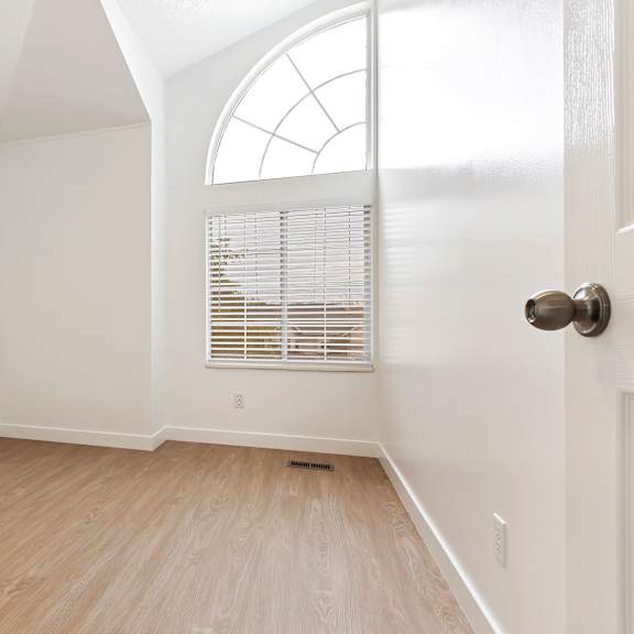 a room with a wooden floor and a white door.