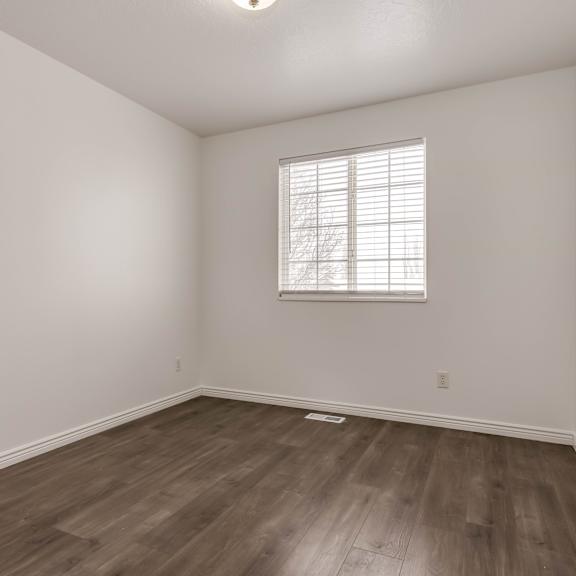 a room with a window and wooden flooring.