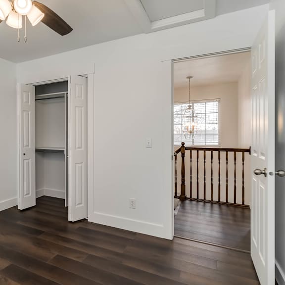 a room with a ceiling fan and wooden floors.