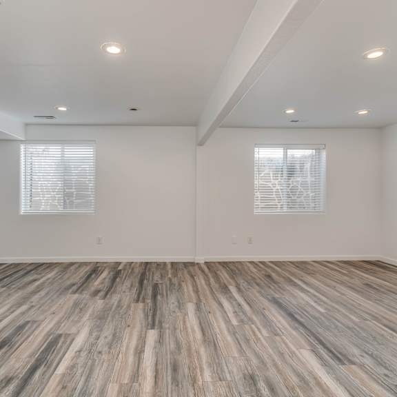 an empty living room with wood floors and white walls