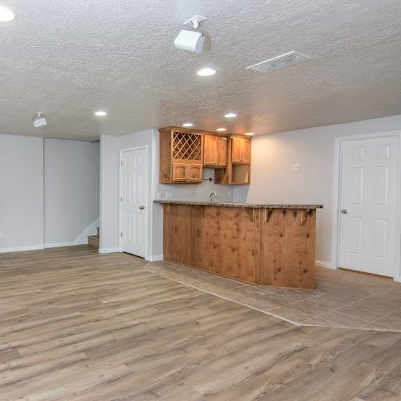 an empty living room and kitchen with wood flooring