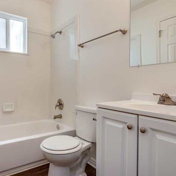 a bathroom with a toilet and a tub and a sink