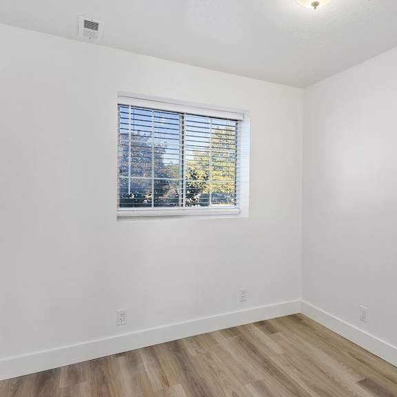 an empty room with white walls and a window