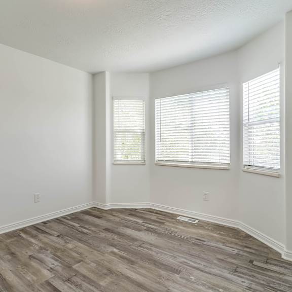 an empty living room with white walls and wood flooring