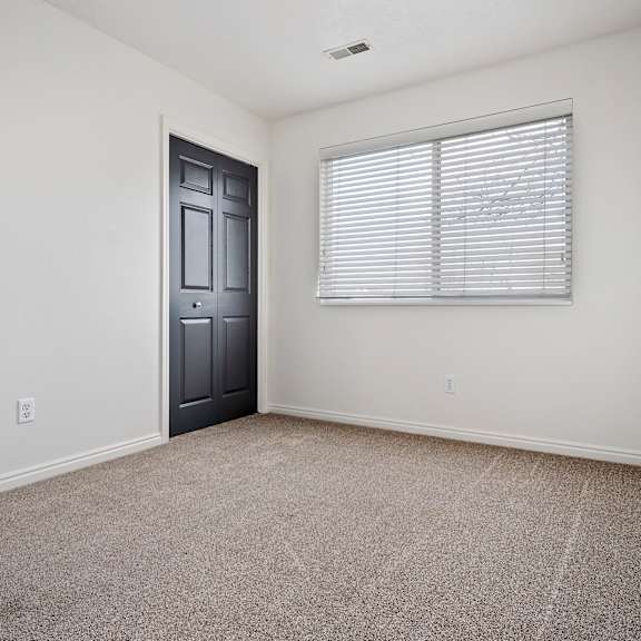 an empty room with a window and a door