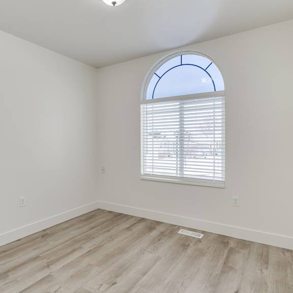 a room with a window and wooden flooring.