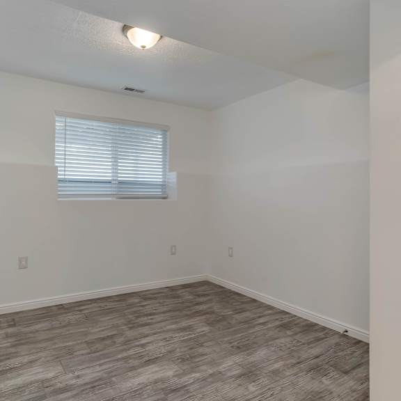 a room with a window and wooden flooring.