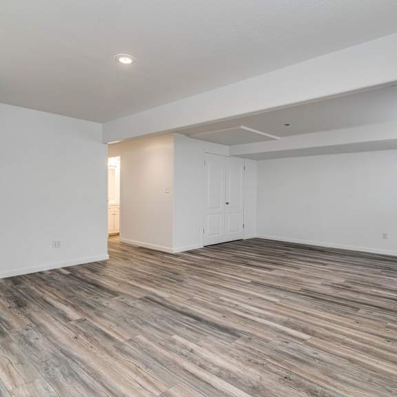 a living room with white walls and wood floors
