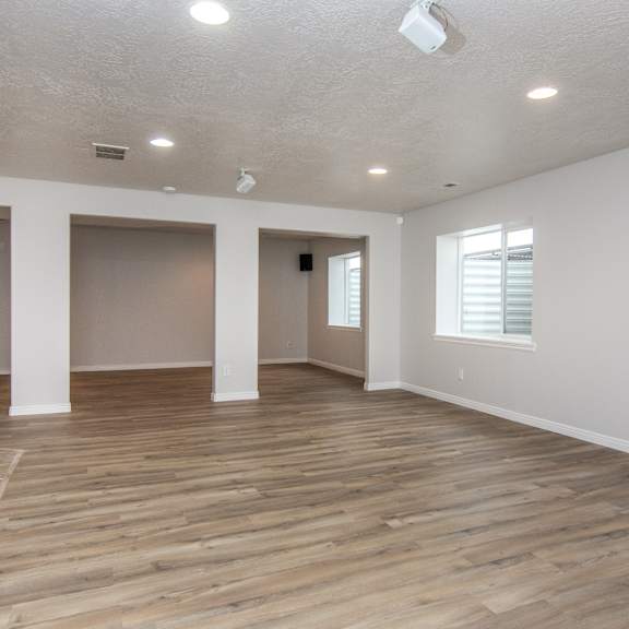 an empty living room with a wooden floor and white walls