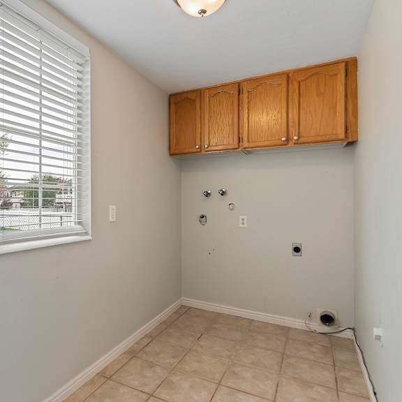 an empty room with a large window and tile flooring