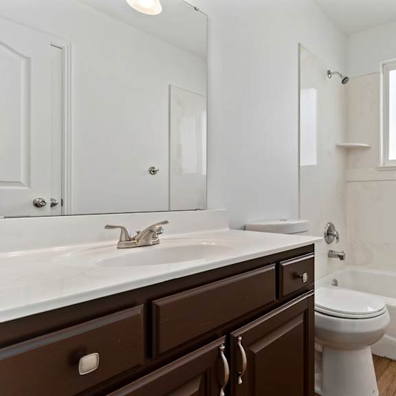 a white bathroom with a toilet, sink, and tub.