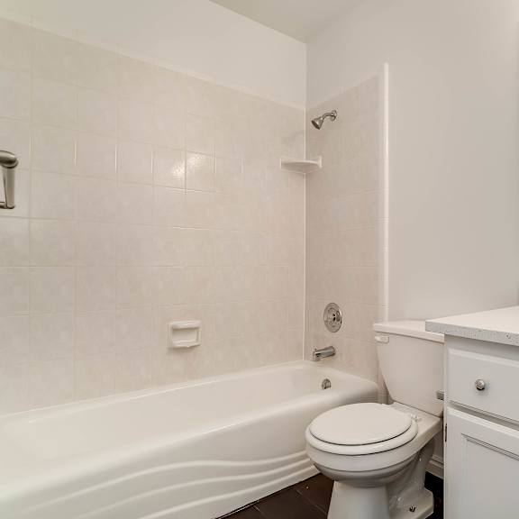a white bathroom with a toilet, sink, and bathtub.