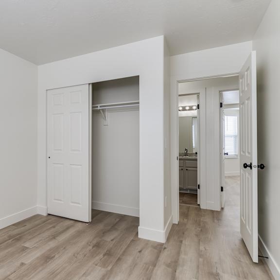 a room with a white door and a wooden floor.