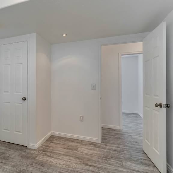 a white door is in a room with a light colored wall.