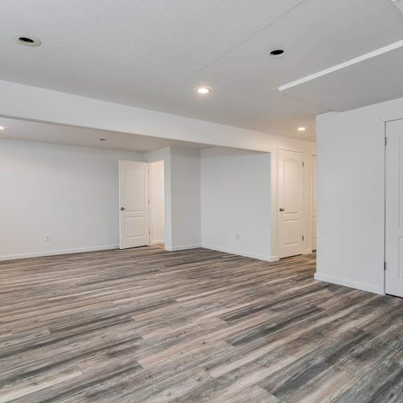 a living room with white walls and wood flooring