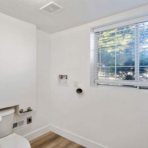 a bathroom with a sink and a toilet and a window