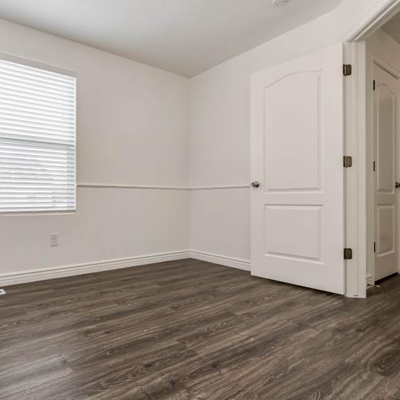 an empty room with a door and a window