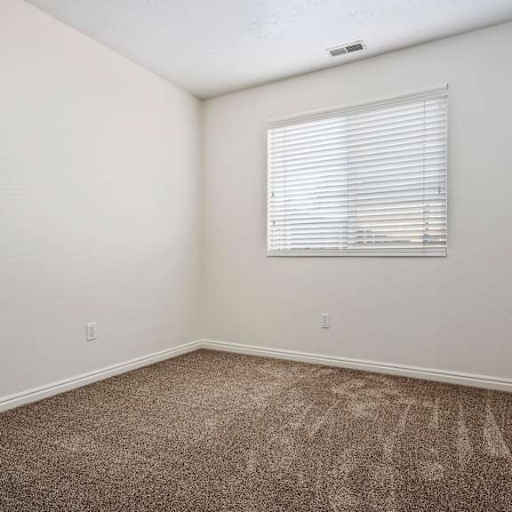 an empty room with carpet and a window