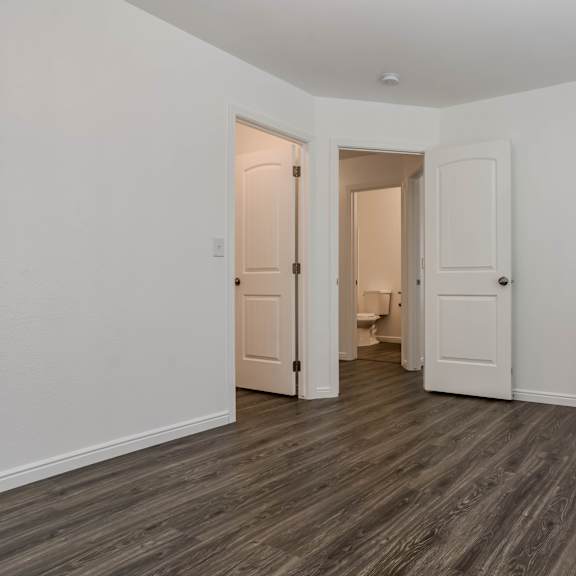 a room with two doors and a wooden floor.