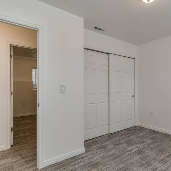 a room with a white door and a grey floor.